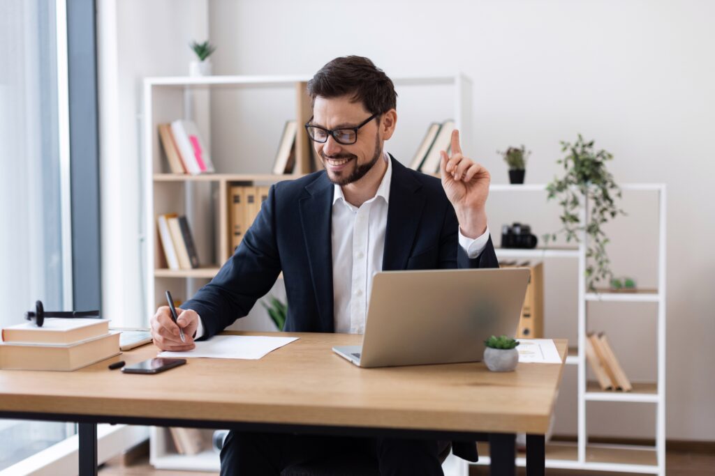 Young,Adult,Caucasian,Male,Sitting,At,Computer,Writing,Notes,In
