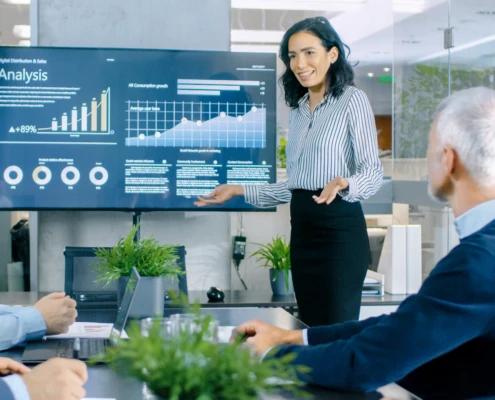 Young professional woman smiling confidently while standing in a modern office setting